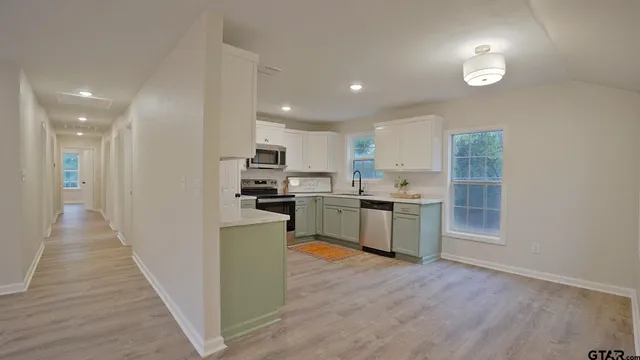 a kitchen with stainless steel appliances a refrigerator sink and cabinets