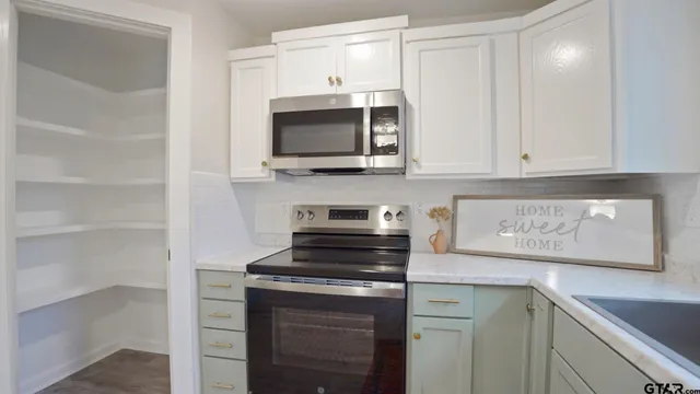 a kitchen with stainless steel appliances granite countertop a stove microwave and oven