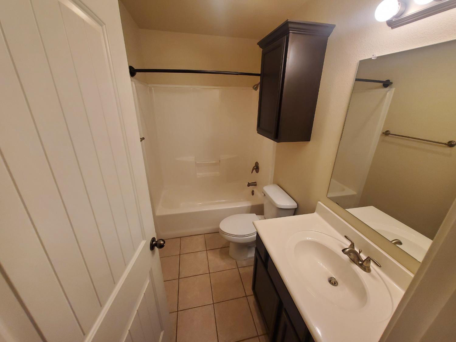 5603 110th Street Lubbock, TX 79424 - Photo 9 of 12 a bathroom with a sink and mirror with toilet