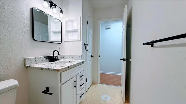 a bathroom with a granite countertop sink and a mirror
