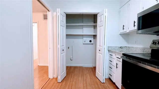 a kitchen with wooden floor and a microwave