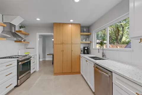 a kitchen with stainless steel appliances granite countertop a refrigerator and a stove