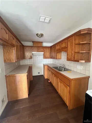 a large kitchen with stainless steel appliances granite countertop a sink and cabinets