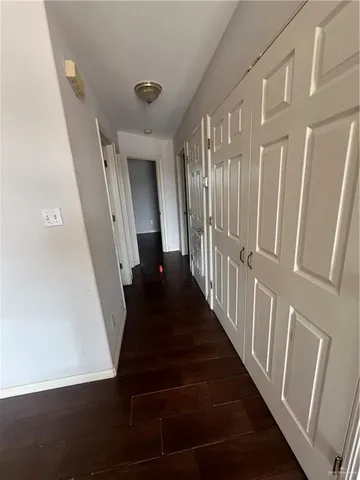 a view of a hallway with wooden floor and stairs