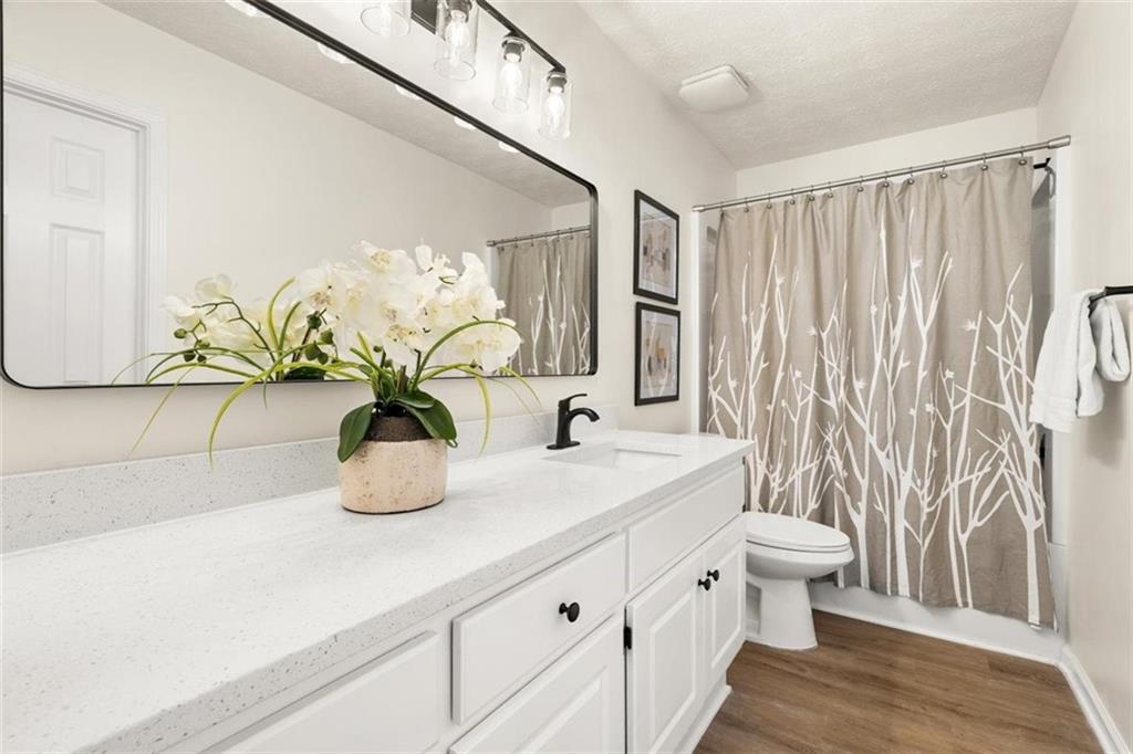 540 Riverside Road Sugar Hill, GA 30518 - Photo 13 of 25 a bathroom with a sink a toilet and a shower curtain