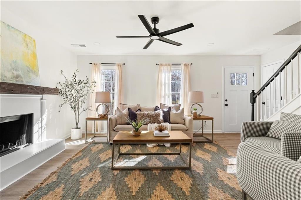 540 Riverside Road Sugar Hill, GA 30518 - Photo 4 of 25 a living room with furniture a fireplace and a flat screen tv