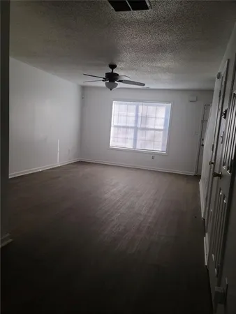 en empty room with windows and ceiling fan