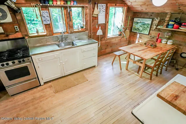 a kitchen with a refrigerator and wooden floor