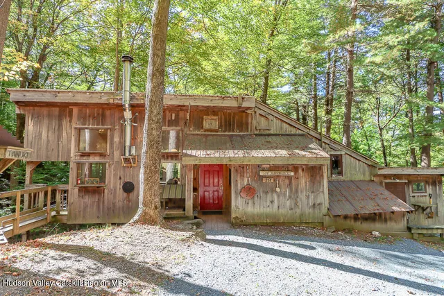 a front view of a house with a tree