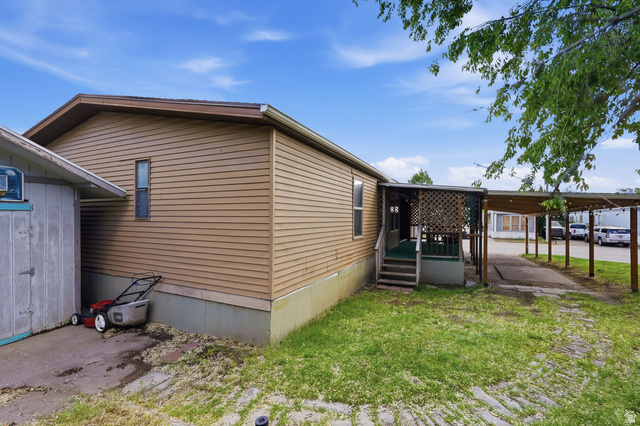 2875 North Hill Field Road, Unit 111 Layton, UT 84041 - Photo 25 of 30 View of side of home featuring a yard and an attached carport