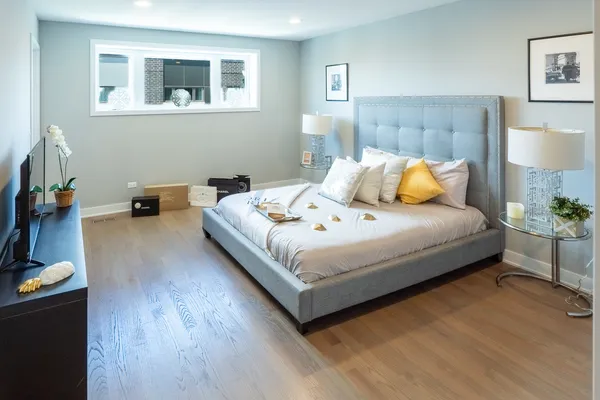 a bedroom with a bed and a lamp on the dresser