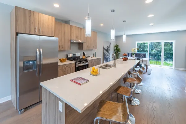 a kitchen with sink refrigerator and wooden floor