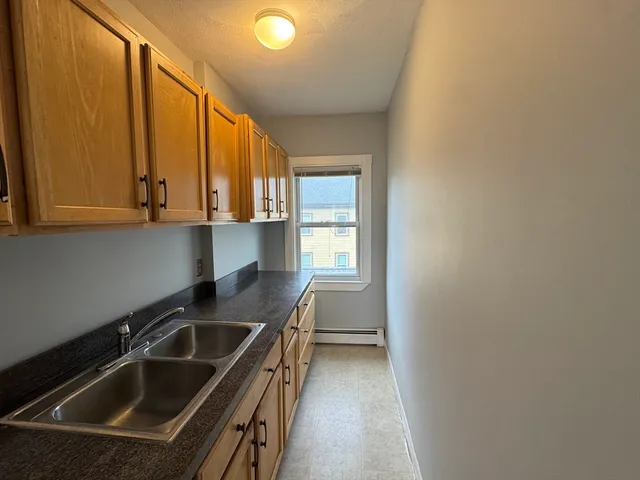 a kitchen with a sink cabinets and window