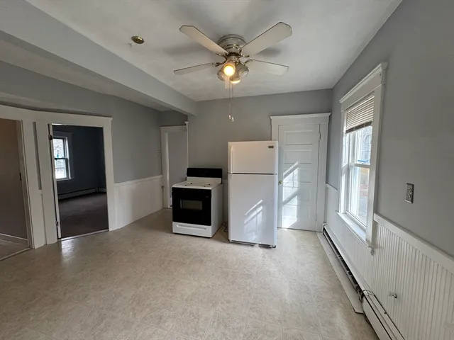 a view of a livingroom with a ceiling fan and refrigerator