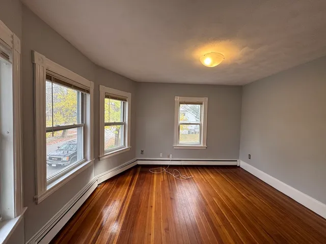 wooden floor in an empty room with a window