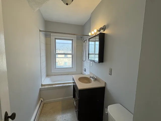 a bathroom with a sink toilet a mirror and bathtub