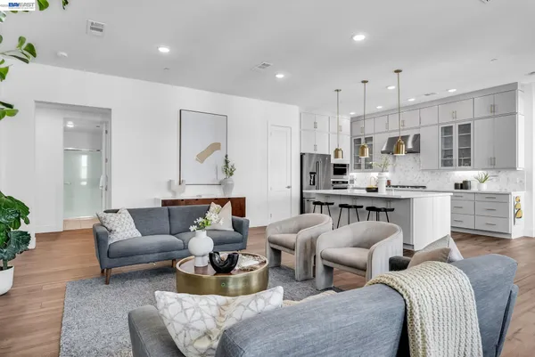 a living room with furniture kitchen view and large windows