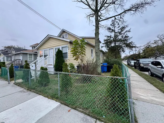 a front view of a house with a yard and potted plants