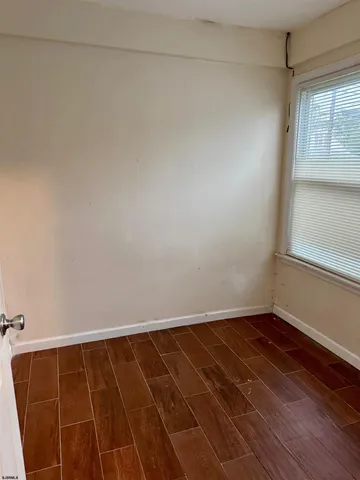 a view of a room with wooden floor and a window