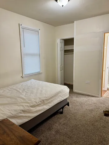 a bed sitting in a bedroom next to a window