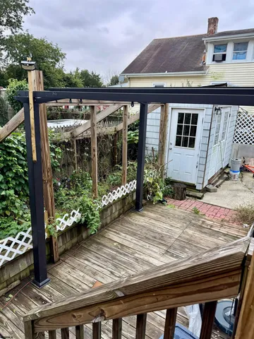 a view of a house with a small yard and wooden fence