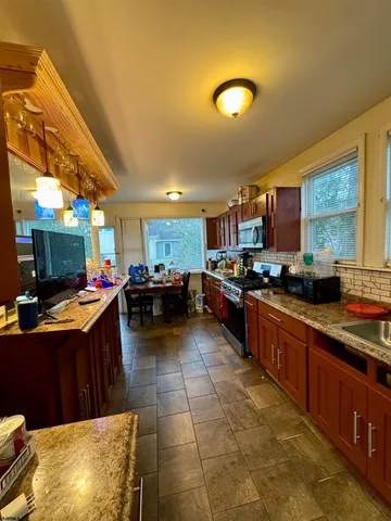 a kitchen with stainless steel appliances granite countertop a sink counter space cabinets and a couch