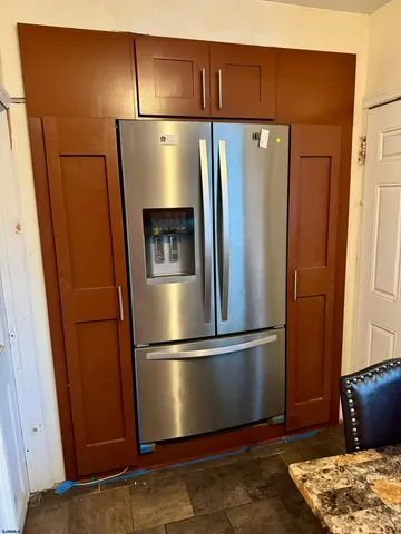 a metallic refrigerator freezer sitting in a kitchen