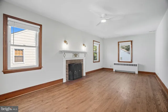 a view of empty room with a fireplace and wooden floor
