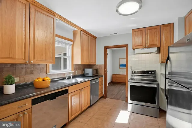 a kitchen with a refrigerator sink and cabinets