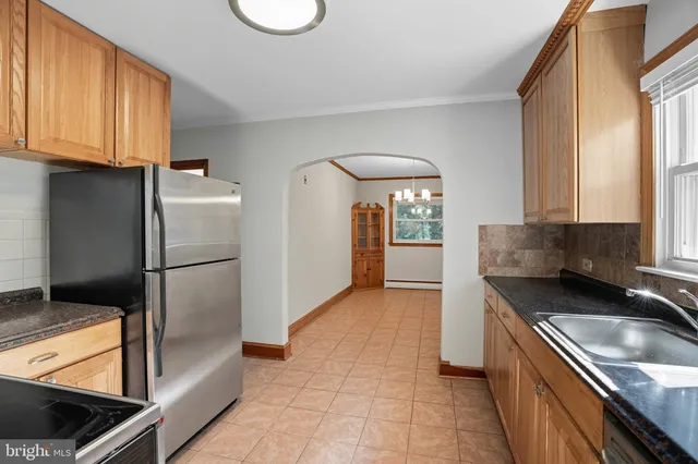 an empty room with chandelier fan and windows