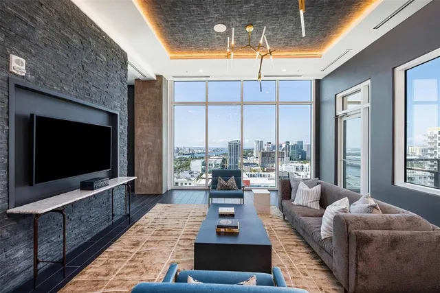 a living room with furniture a chandelier and a large window