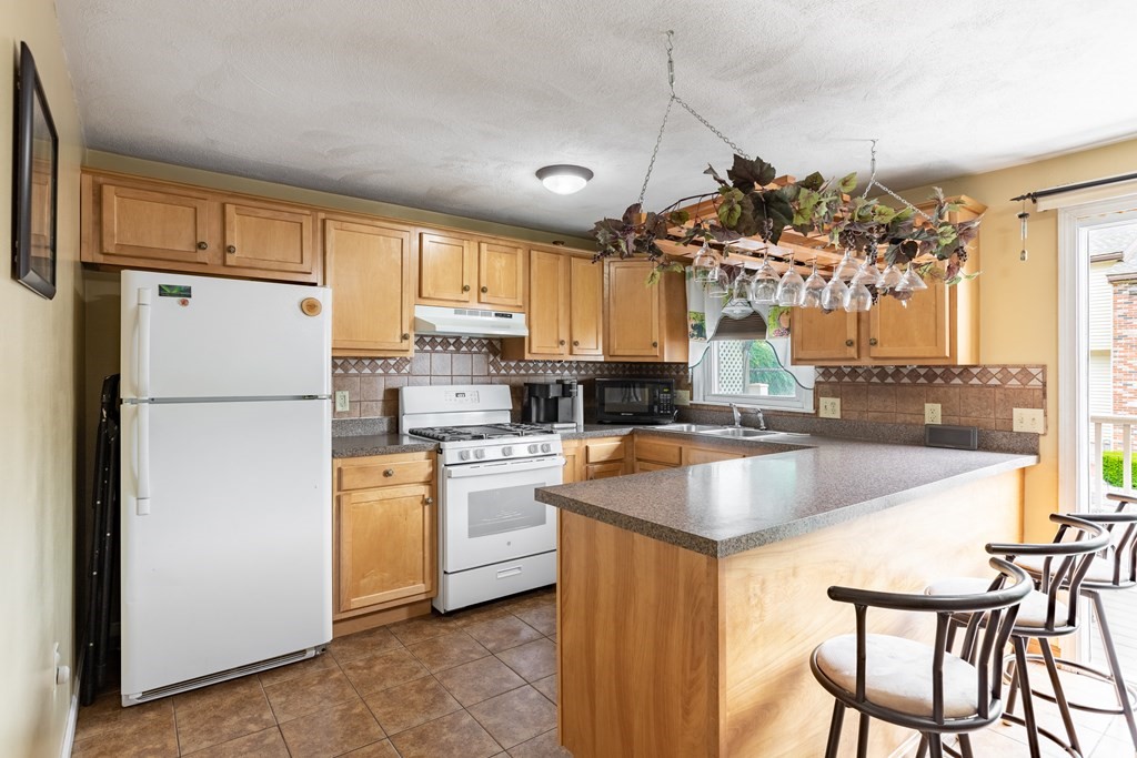 3 Woodland Street, Unit 16 Lawrence, MA 01841 - Photo 12 of 29 a kitchen with refrigerator a stove a sink and cabinets