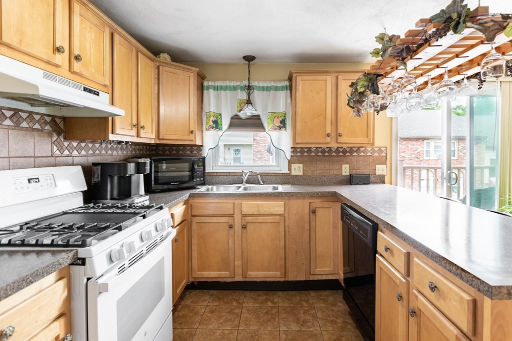 3 Woodland Street, Unit 16 Lawrence, MA 01841 - Photo 14 of 29 a kitchen with kitchen island granite countertop a sink stove and cabinets