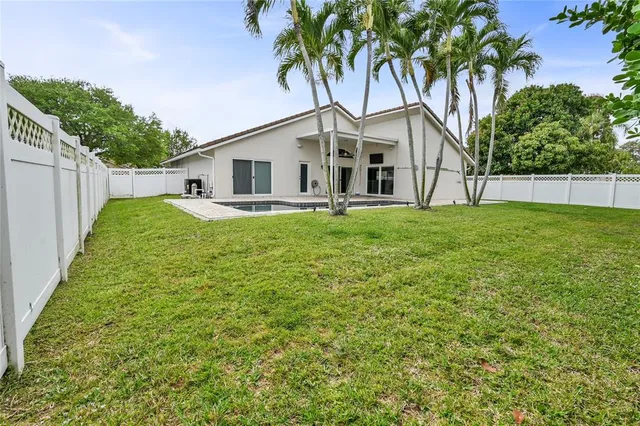 a view of a backyard with plants and palm tree