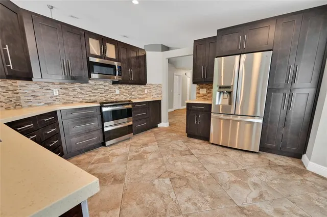 a kitchen with stainless steel appliances granite countertop a refrigerator stove and sink
