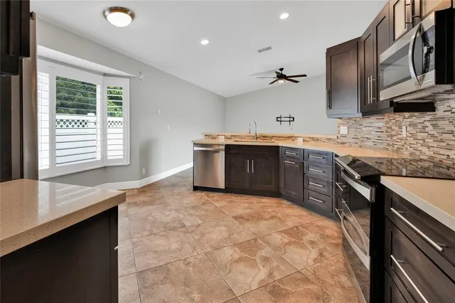 a large kitchen with stainless steel appliances granite countertop a sink and a stove