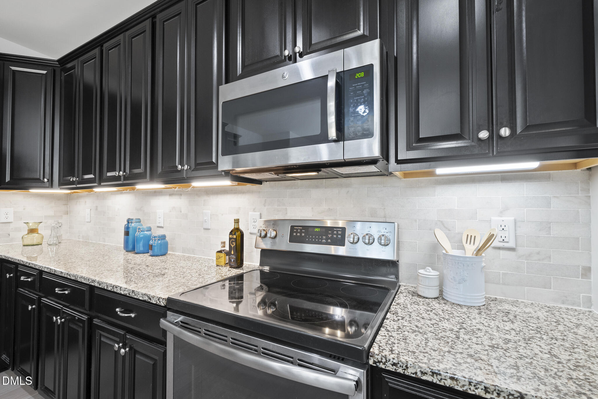 332 Forbes Road Wake Forest, NC 27587 - Photo 11 of 32 a kitchen with granite countertop a stove top oven microwave and cabinets