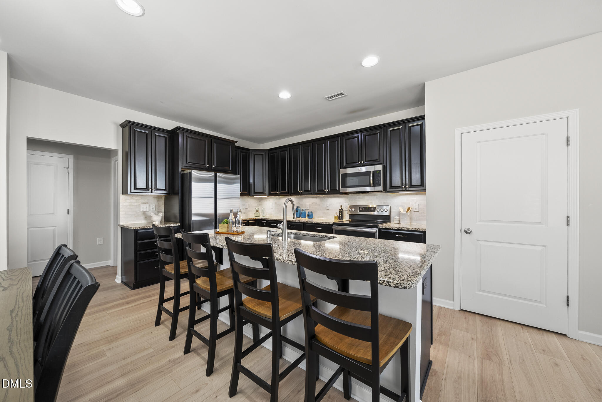 332 Forbes Road Wake Forest, NC 27587 - Photo 9 of 32 a kitchen with stainless steel appliances kitchen island granite countertop a table chairs and a refrigerator
