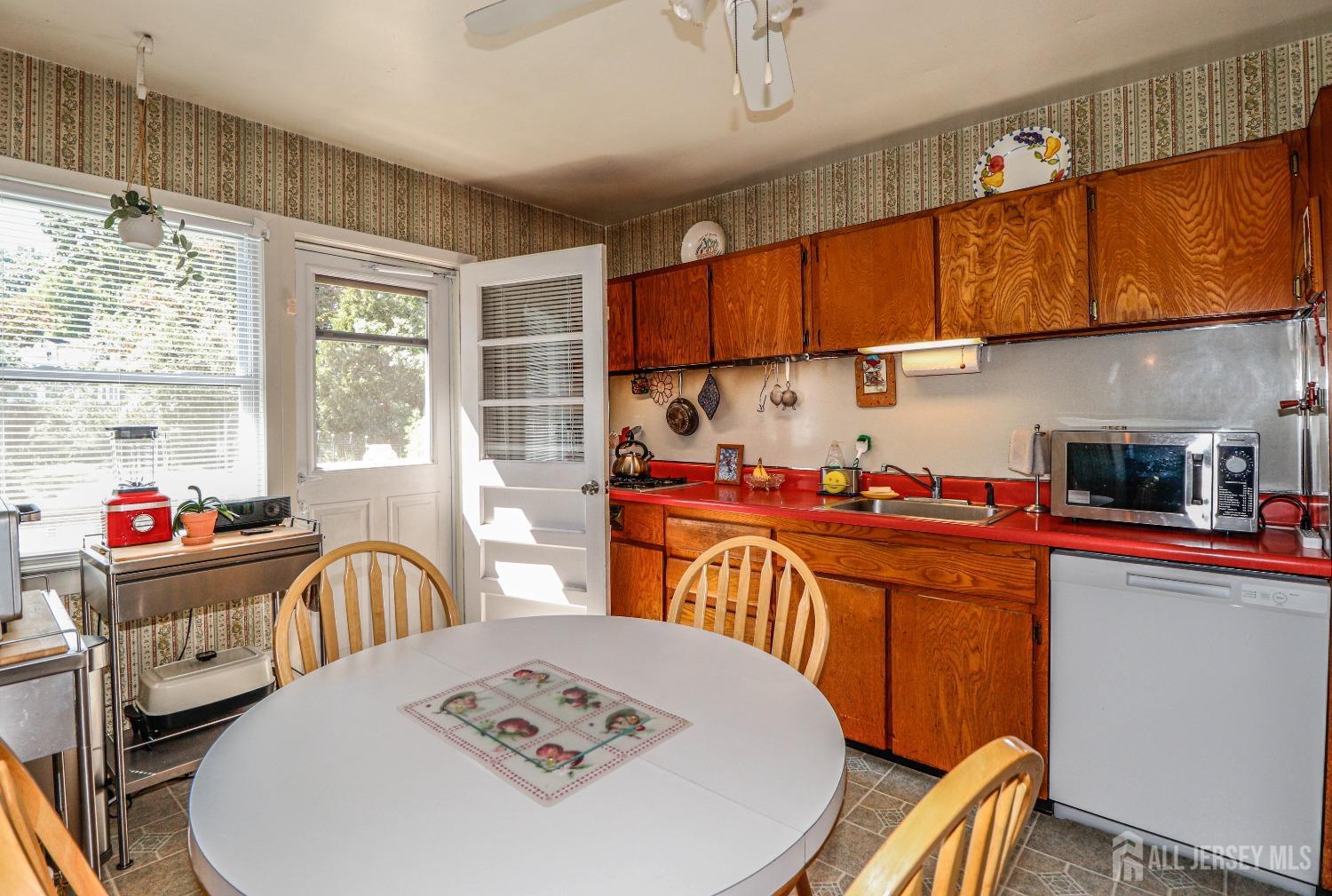 33 Harmon Road Edison, NJ 08837 - Photo 11 of 25 a kitchen with stainless steel appliances wooden floor dining table and chairs