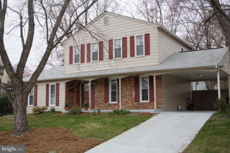 6512 Darwin Road Laurel, MD 20707 - Photo 1 of 22 a front view of a house with a garden and trees