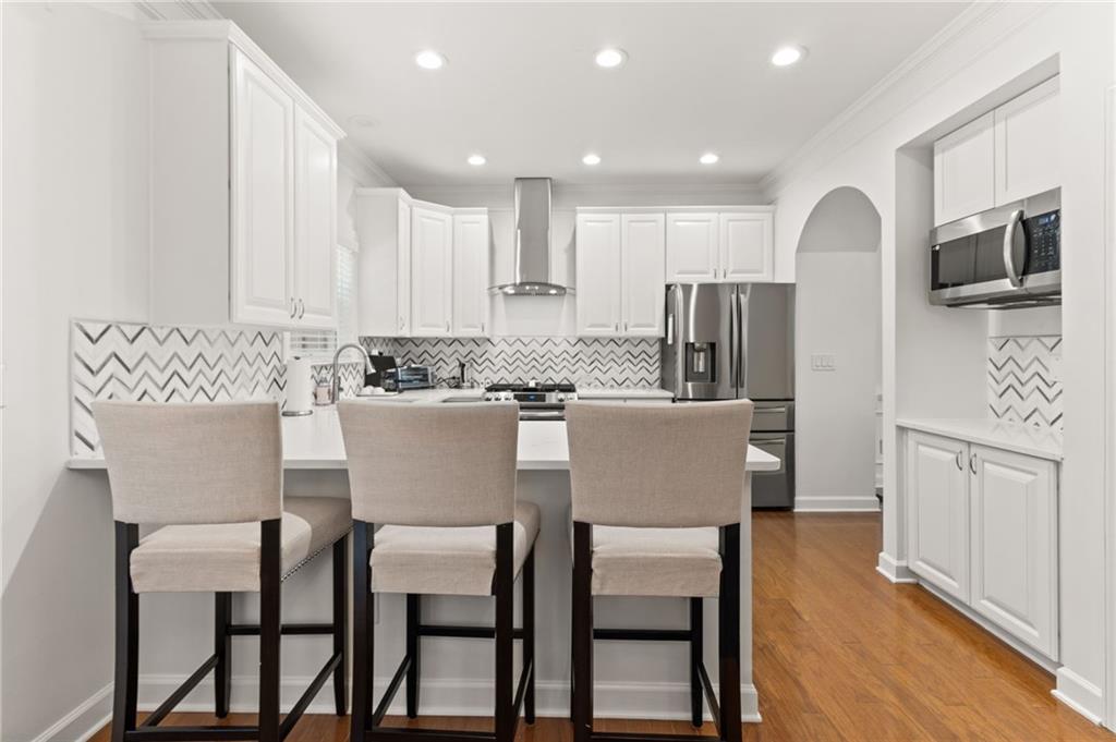2086 Cobblestone Circle Northeast Atlanta, GA 30319 - Photo 16 of 34 a kitchen with stainless steel appliances granite countertop a dining table chairs refrigerator and microwave