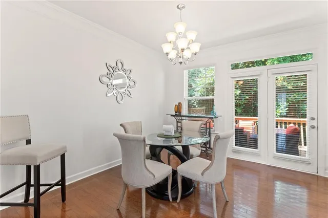 a view of a dining room with furniture a chandelier and wooden floor