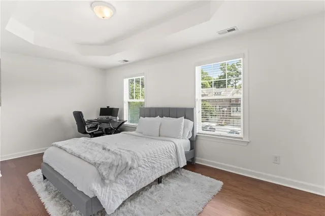 a large bedroom with a bed and wooden floor