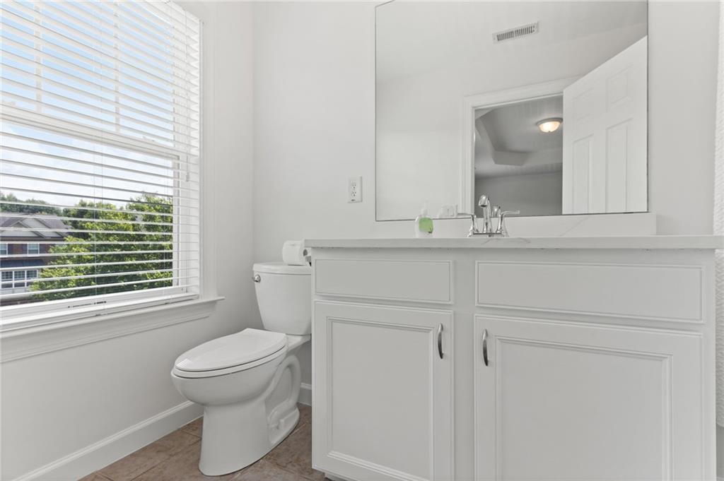 2086 Cobblestone Circle Northeast Atlanta, GA 30319 - Photo 31 of 34 a bathroom with a toilet sink vanity and mirror