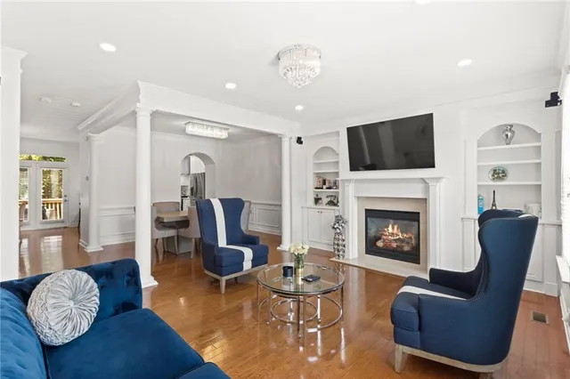 a living room with furniture a flat screen tv and a fireplace