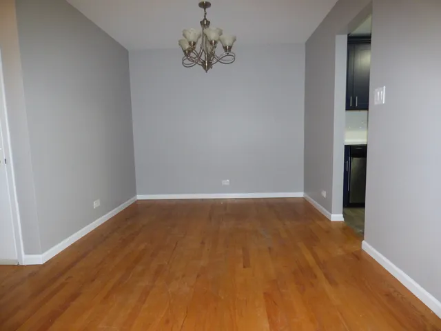 a view of an empty room with a chandelier fan