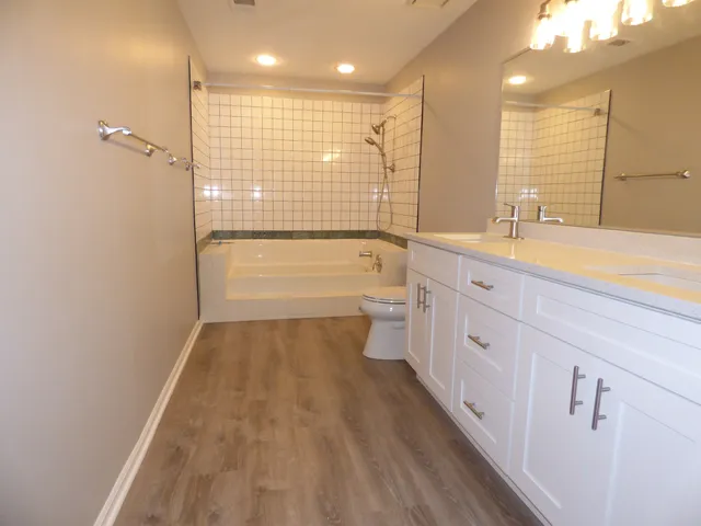 a bathroom with a double vanity sink a mirror and a bathtub