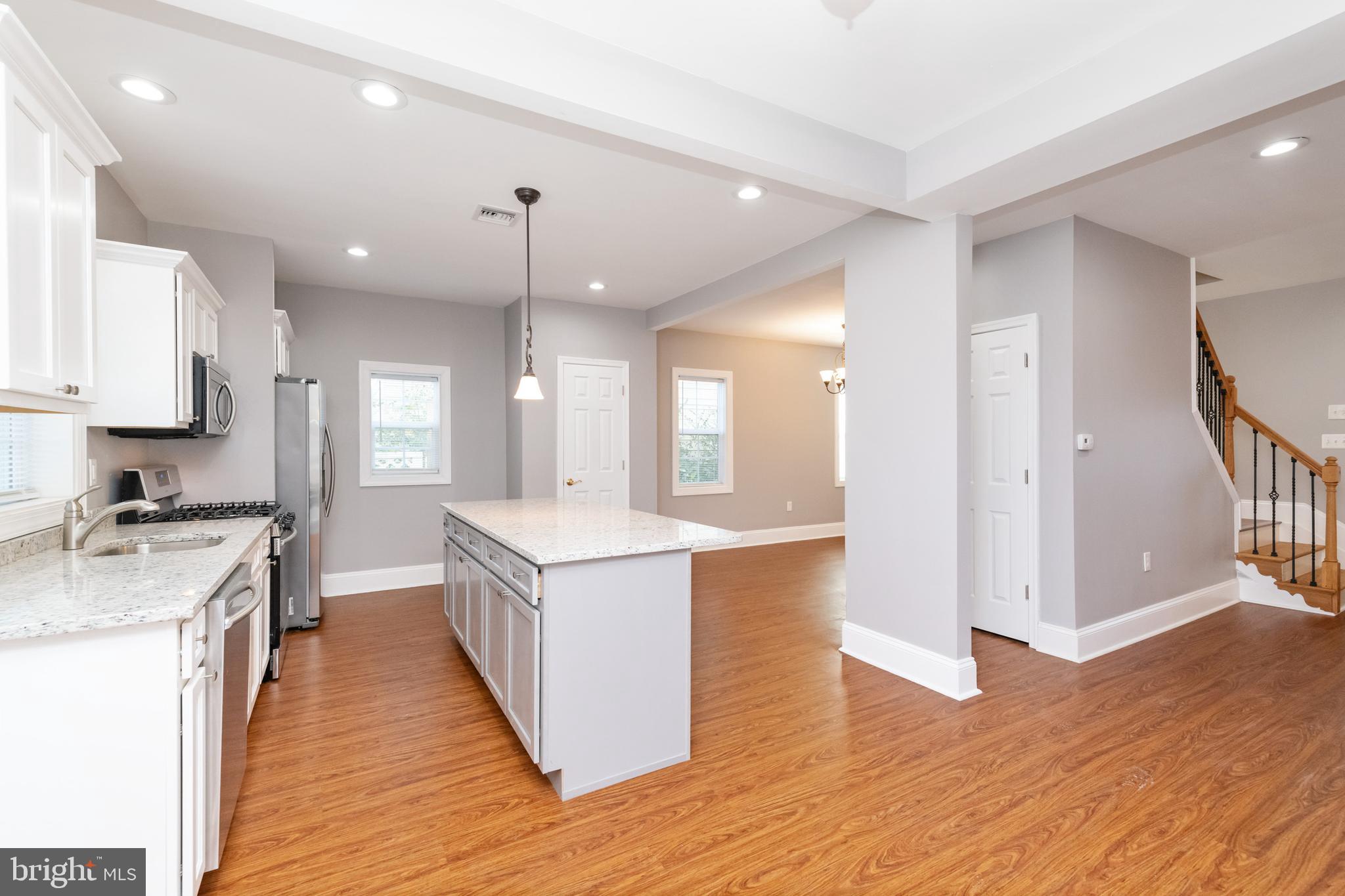2505 Hammonds Ferry Road Baltimore, MD 21227 - Photo 11 of 36 a kitchen with stainless steel appliances granite countertop wooden floors and white walls