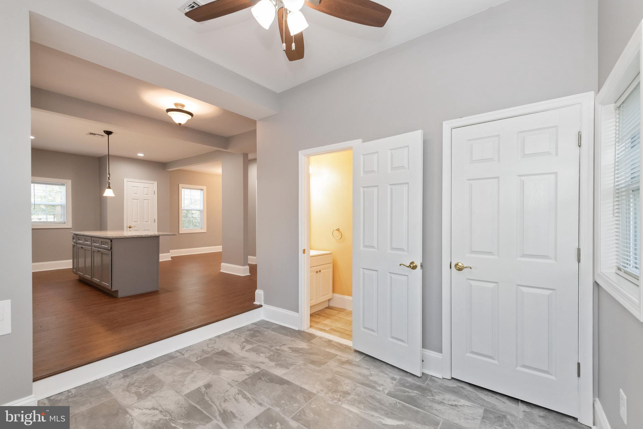 2505 Hammonds Ferry Road Baltimore, MD 21227 - Photo 18 of 36 an empty room with wooden floor and a kitchen