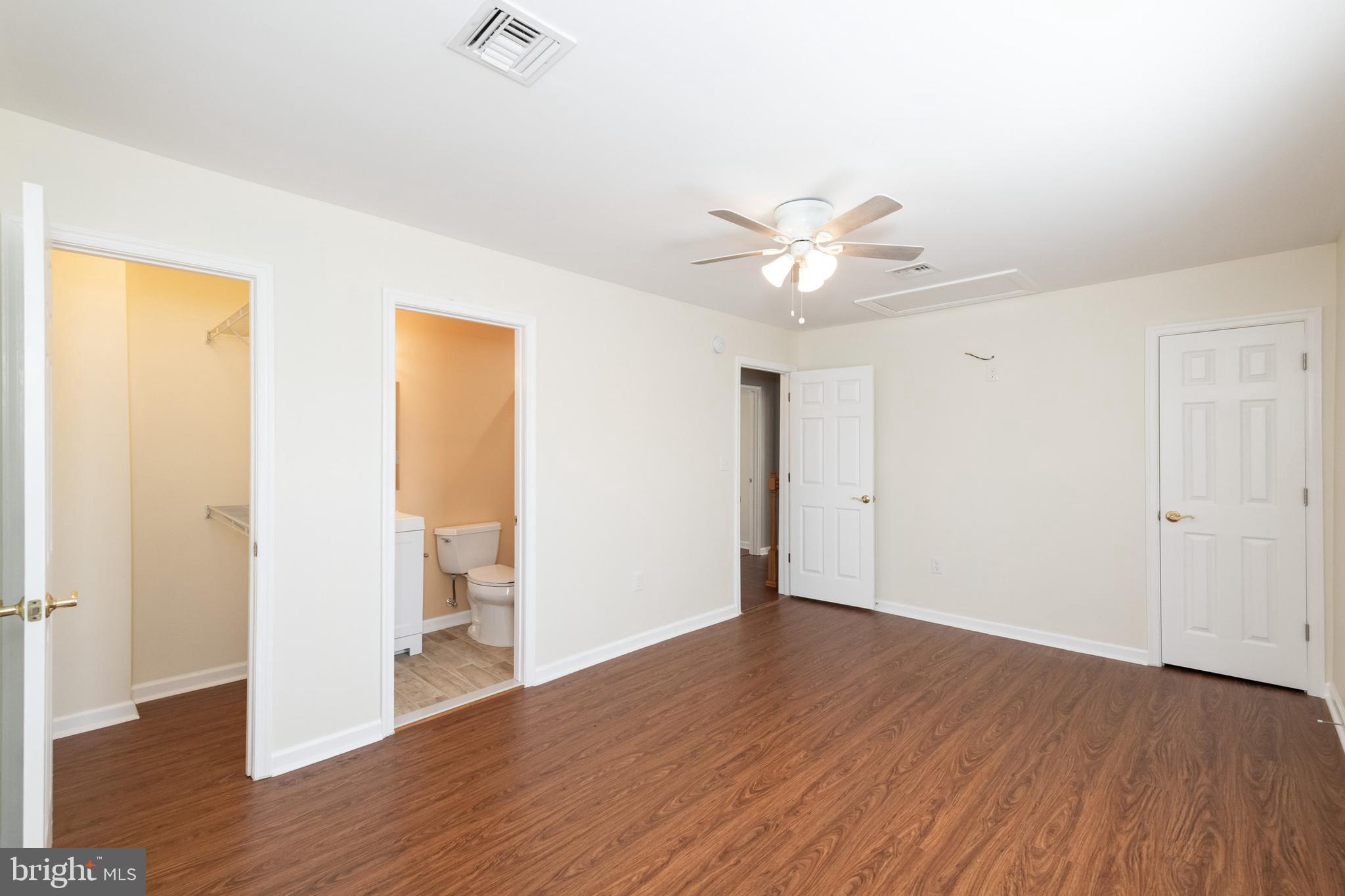 2505 Hammonds Ferry Road Baltimore, MD 21227 - Photo 23 of 36 an empty room with wooden floor and a ceiling fan